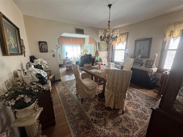 5307 65th Pl, Maspeth, NY 11378 - dining room featuring a chandelier, arched walkways, and dark wood finished floors
