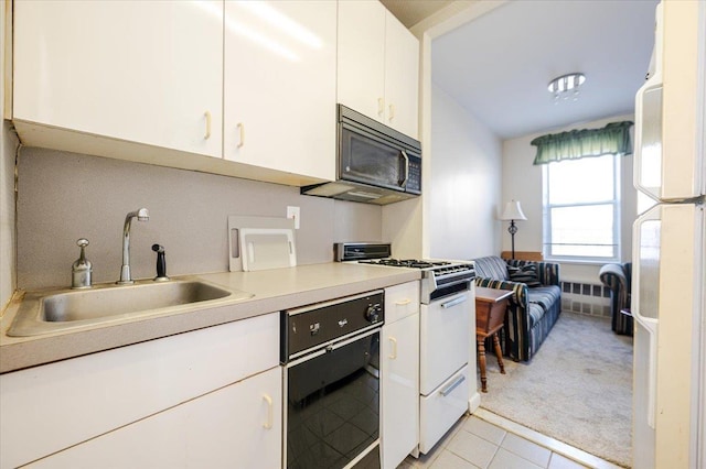 16 Main St Unit 3Y, East Rockaway, NY 11518 - kitchen with white appliances, a sink, light countertops, light carpet, and white cabinets