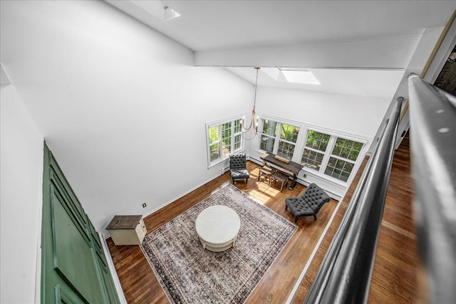 18 Stirrup Ln, Glen Cove, NY 11542 - living area with a skylight, a chandelier, high vaulted ceiling, wood finished floors, and baseboards