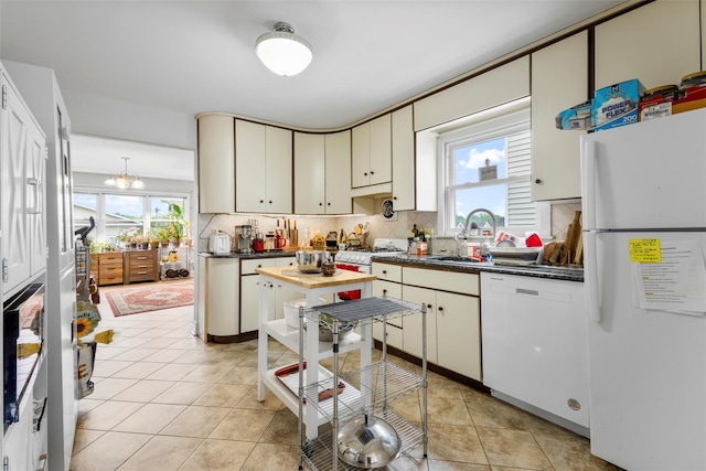 11 Parsons St, Harrison, NY 10528 - kitchen featuring white appliances, a sink, dark countertops, backsplash, and light tile patterned floors