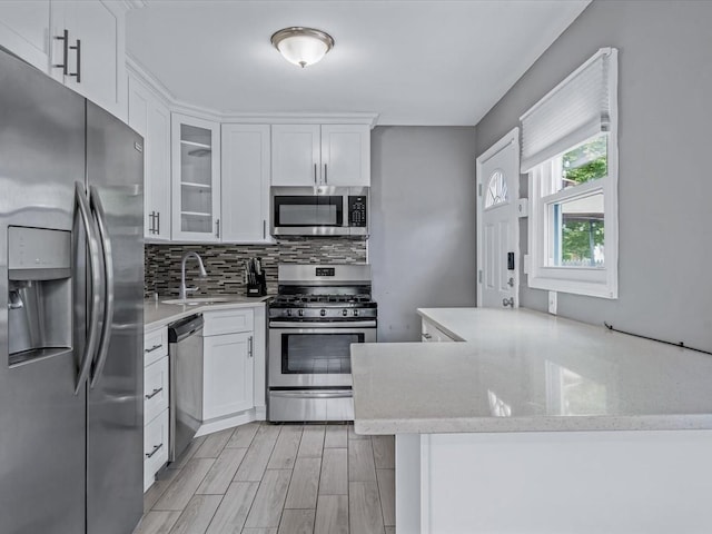 251 Woods Rd, North Babylon, NY 11703 - kitchen featuring appliances with stainless steel finishes, a sink, tasteful backsplash, and white cabinets