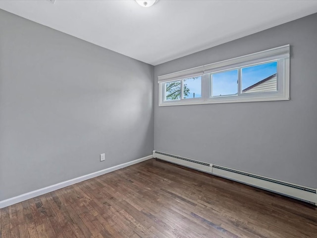 251 Woods Rd, North Babylon, NY 11703 - empty room with a baseboard heating unit, wood finished floors, and baseboards