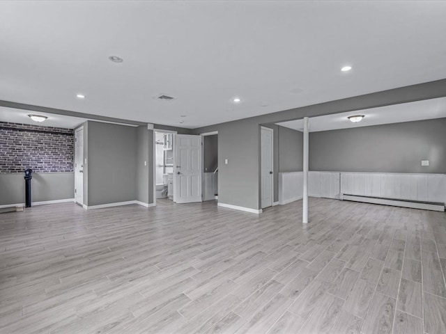 251 Woods Rd, North Babylon, NY 11703 - unfurnished living room featuring a baseboard radiator, light wood-type flooring, recessed lighting, and baseboards