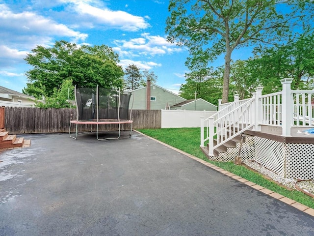 251 Woods Rd, North Babylon, NY 11703 - view of yard with a trampoline, a wooden deck, and stairs