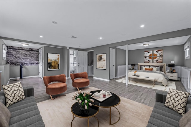 251 Woods Rd, North Babylon, NY 11703 - living room with wood finished floors, baseboards, recessed lighting, and brick wall