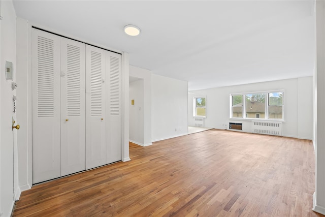 415 Gramatan Ave Unit 2C, Mount Vernon, NY 10552 - unfurnished living room featuring radiator, light wood-style floors, and baseboards
