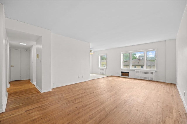 415 Gramatan Ave Unit 2C, Mount Vernon, NY 10552 - unfurnished living room with radiator heating unit, light wood-type flooring, baseboards, and a ceiling fan