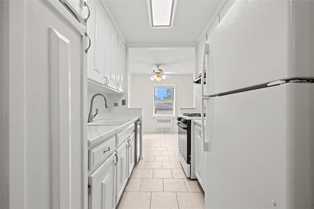 415 Gramatan Ave Unit 2C, Mount Vernon, NY 10552 - kitchen with freestanding refrigerator, gas range oven, radiator heating unit, a sink, and ceiling fan