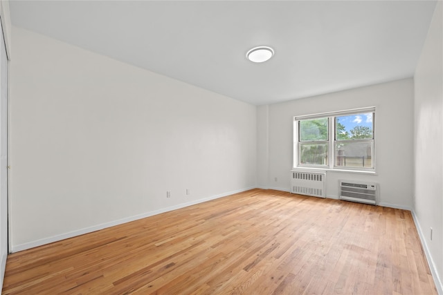 415 Gramatan Ave Unit 2C, Mount Vernon, NY 10552 - unfurnished room with radiator, light wood-style flooring, baseboards, and a wall unit AC