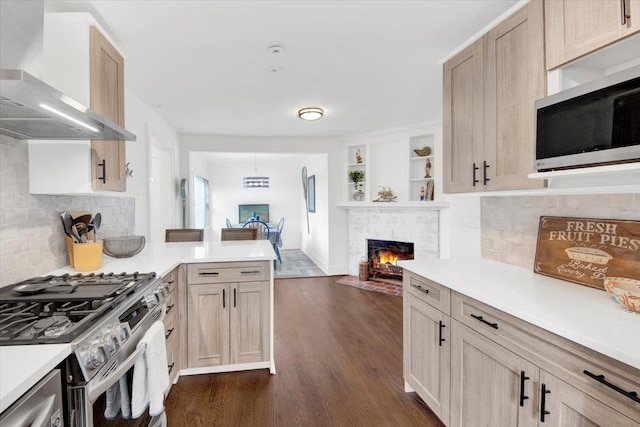 211 Bowne St, Bronx, NY 10464 - kitchen featuring wall chimney exhaust hood, stainless steel appliances, light countertops, and a peninsula