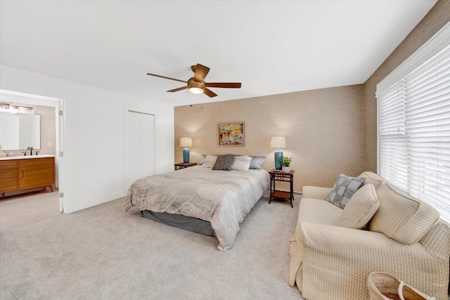 211 Bowne St, Bronx, NY 10464 - bedroom featuring a closet, light colored carpet, a sink, a ceiling fan, and connected bathroom