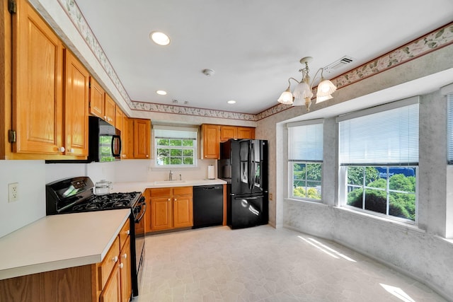 192 Theodore Dr, Coram, NY 11727 - kitchen with black appliances, a sink, a chandelier, light countertops, and brown cabinetry