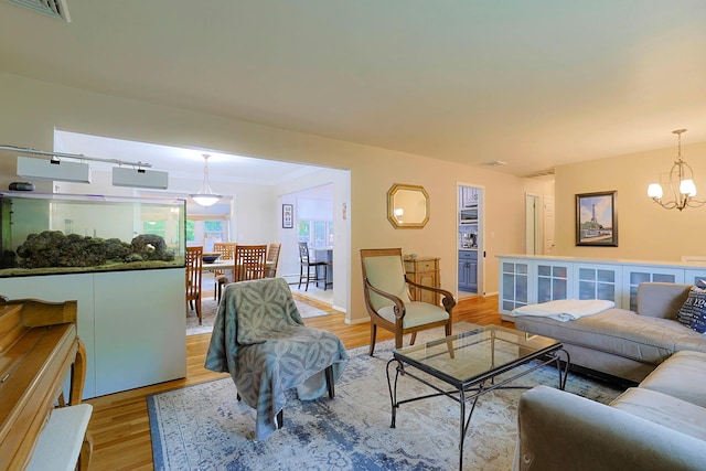 10 Cregan Pl, Monroe, NY 10950 - living room with light wood-style flooring, a chandelier, and crown molding