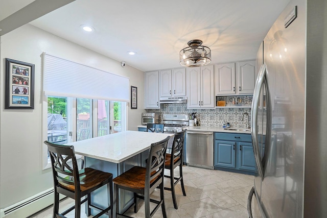10 Cregan Pl, Monroe, NY 10950 - kitchen featuring appliances with stainless steel finishes, under cabinet range hood, a sink, baseboard heating, and decorative backsplash