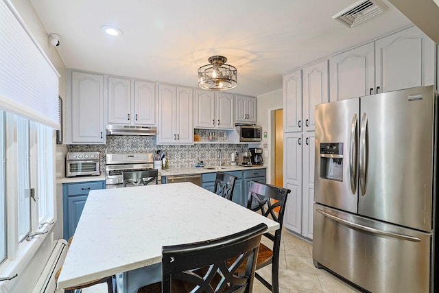 10 Cregan Pl, Monroe, NY 10950 - kitchen with appliances with stainless steel finishes, under cabinet range hood, a sink, tasteful backsplash, and light tile patterned floors