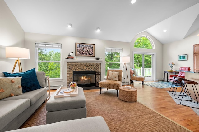 72 Greencrest Rd, Goshen, NY 10924 - living area featuring baseboard heating, wood finished floors, a tile fireplace, lofted ceiling, and a baseboard heating unit