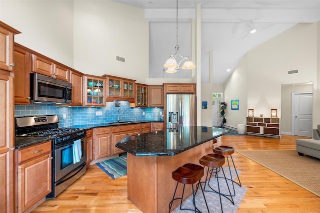 72 Greencrest Rd, Goshen, NY 10924 - kitchen featuring appliances with stainless steel finishes, a sink, high vaulted ceiling, a kitchen breakfast bar, and a center island