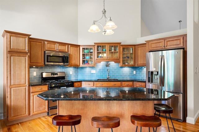 72 Greencrest Rd, Goshen, NY 10924 - kitchen with stainless steel appliances, a sink, high vaulted ceiling, brown cabinets, and a kitchen bar