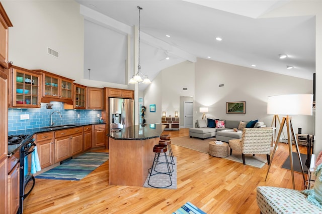 72 Greencrest Rd, Goshen, NY 10924 - kitchen with stainless steel fridge with ice dispenser, a sink, black range with gas stovetop, brown cabinets, and light wood-style floors
