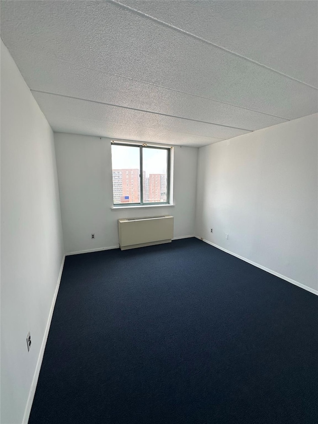 97-12 63rd Dr Unit 10D, Rego Park, NY 11374 - spare room featuring a textured ceiling and dark carpet