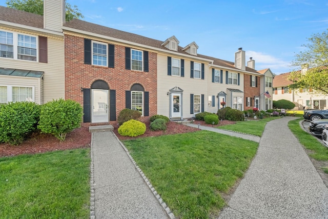 8 Moore Ln, Washingtonville, NY 10992 - view of property with a residential view, a front lawn, a chimney, and brick siding
