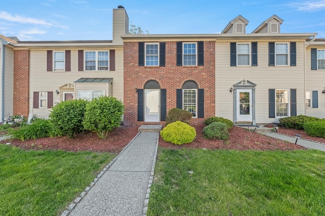 8 Moore Ln, Washingtonville, NY 10992 - view of front facade featuring a front lawn, brick siding, and a chimney