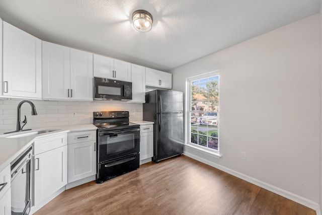 8 Moore Ln, Washingtonville, NY 10992 - kitchen with black appliances, a sink, light wood-style flooring, tasteful backsplash, and baseboards