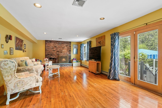 14 Battle Row, Old Bethpage, NY 11804 - living area with a baseboard heating unit, light wood-style flooring, a brick fireplace, and recessed lighting