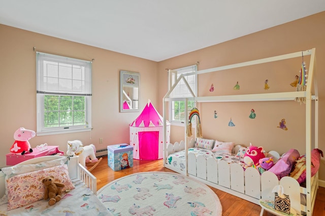 14 Battle Row, Old Bethpage, NY 11804 - bedroom featuring wood finished floors and a baseboard heating unit