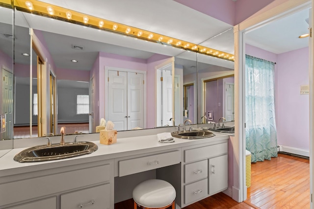 14 Battle Row, Old Bethpage, NY 11804 - bathroom featuring double vanity, wood finished floors, and a baseboard heating unit