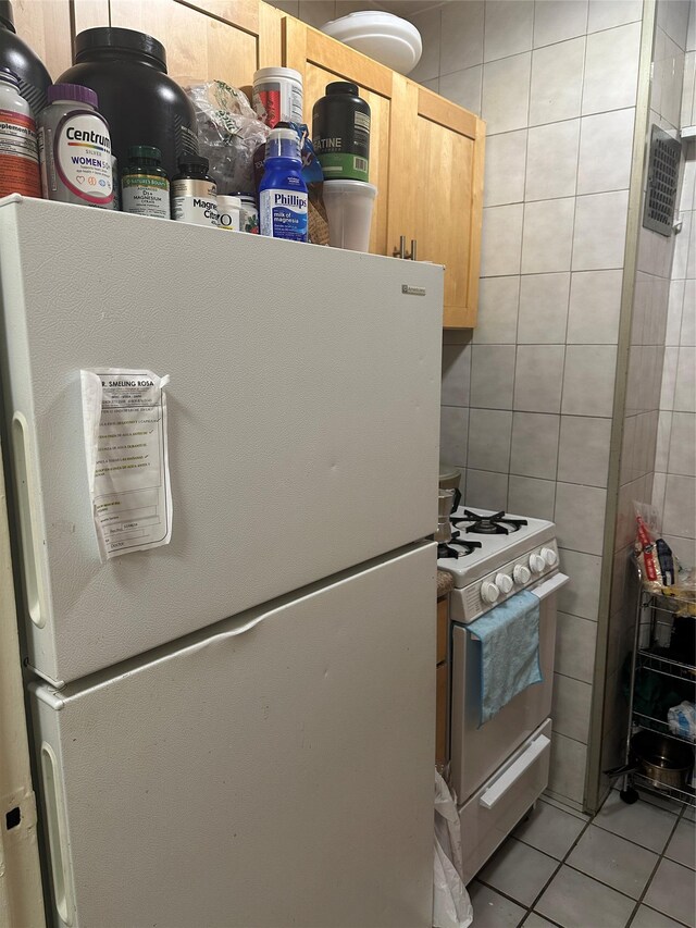 610 Waring Ave Unit 6C, Bronx, NY 10467 - kitchen featuring white appliances, light tile patterned floors, light brown cabinets, and tile walls