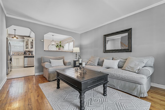 2808 Philip Ave, Bronx, NY 10465 - living area with light wood-style flooring, baseboards, crown molding, and arched walkways