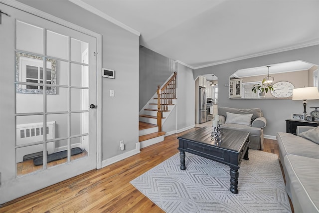 2808 Philip Ave, Bronx, NY 10465 - living area featuring crown molding, stairway, arched walkways, baseboards, and wood finished floors