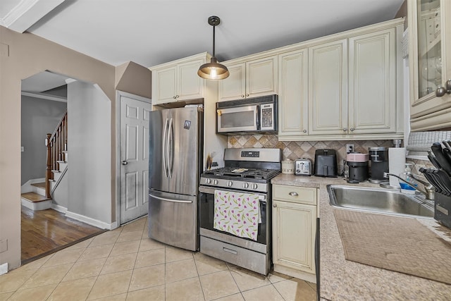 2808 Philip Ave, Bronx, NY 10465 - kitchen featuring cream cabinetry, stainless steel appliances, a sink, light tile patterned flooring, and light countertops