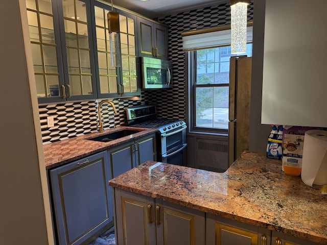 255 Central Ave Unit 202-A, Lawrence, NY 11559 - kitchen featuring stainless steel appliances, a sink, tasteful backsplash, glass insert cabinets, and stone counters