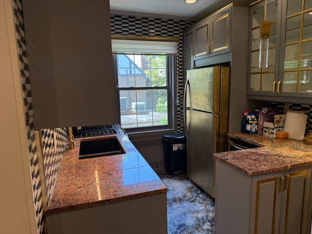 255 Central Ave Unit 202-A, Lawrence, NY 11559 - kitchen featuring freestanding refrigerator, glass insert cabinets, a peninsula, and light stone countertops