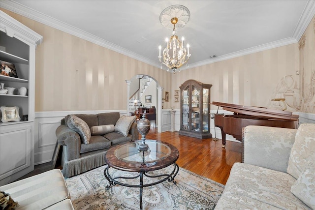 40 Carlisle Ln, East Islip, NY 11730 - living area featuring arched walkways, wallpapered walls, crown molding, wood finished floors, and stairway
