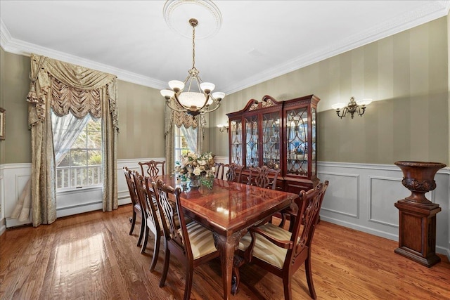 40 Carlisle Ln, East Islip, NY 11730 - dining area featuring a chandelier, a wainscoted wall, wood finished floors, crown molding, and a decorative wall