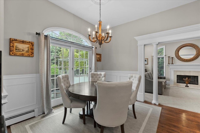 40 Carlisle Ln, East Islip, NY 11730 - dining space with a chandelier, a wainscoted wall, a baseboard radiator, a decorative wall, and a tiled fireplace