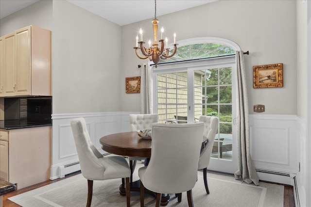 40 Carlisle Ln, East Islip, NY 11730 - dining space with a chandelier, a decorative wall, wainscoting, and light wood-type flooring