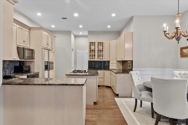 40 Carlisle Ln, East Islip, NY 11730 - kitchen with cream cabinets, black microwave, a center island, light wood-style flooring, and a peninsula