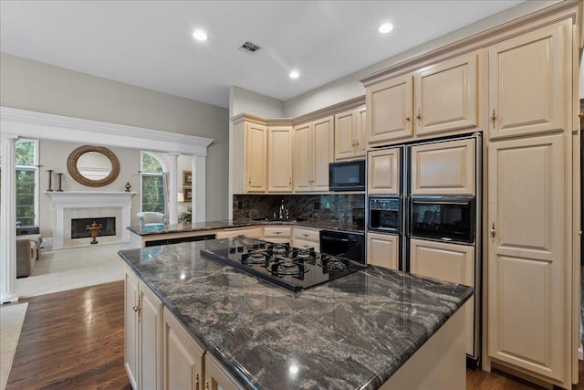 40 Carlisle Ln, East Islip, NY 11730 - kitchen with black appliances, cream cabinetry, a kitchen island, backsplash, and dark wood-style flooring
