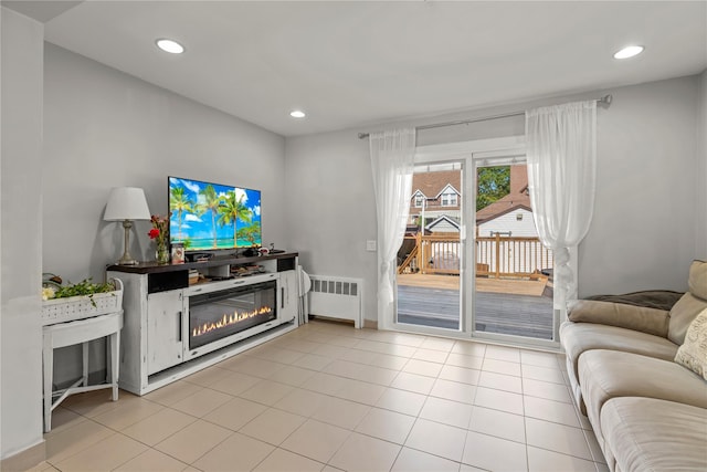 64 Chester Rd, Lynbrook, NY 11563 - living room with radiator heating unit, a glass covered fireplace, recessed lighting, light tile patterned floors, and baseboards