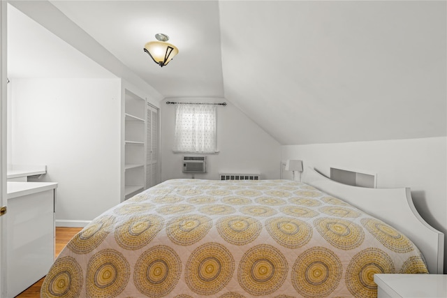 64 Chester Rd, Lynbrook, NY 11563 - bedroom with wood finished floors, lofted ceiling, a wall mounted AC, and baseboards
