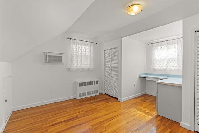 64 Chester Rd, Lynbrook, NY 11563 - additional living space with radiator heating unit, light wood-type flooring, a wall mounted air conditioner, vaulted ceiling, and baseboards