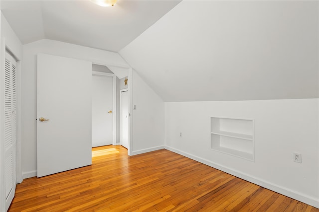 64 Chester Rd, Lynbrook, NY 11563 - additional living space featuring built in shelves, vaulted ceiling, light wood finished floors, and baseboards