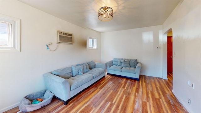 386 Locust Ave, Uniondale, NY 11553 - living room featuring arched walkways, a wall mounted air conditioner, and light wood finished floors