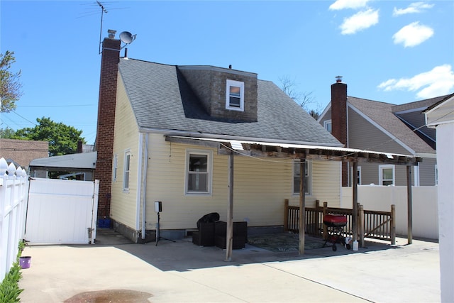 386 Locust Ave, Uniondale, NY 11553 - rear view of house with a patio area, a chimney, and roof with shingles