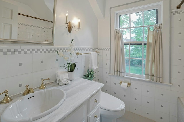 106 Garden Rd, Scarsdale, NY 10583 - full bath with tile walls, toilet, healthy amount of natural light, and vanity
