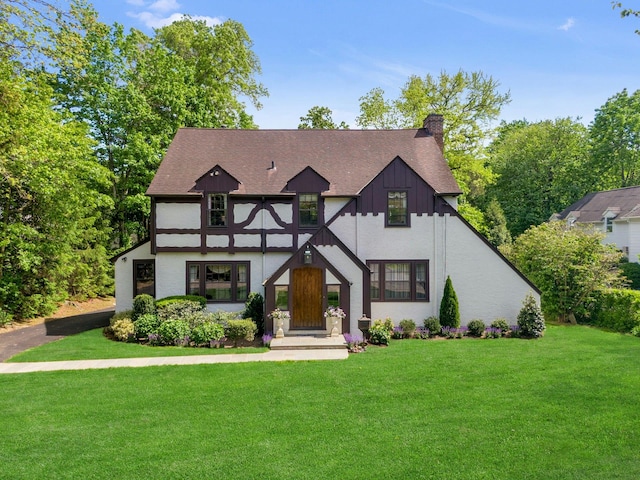 106 Garden Rd, Scarsdale, NY 10583 - english style home featuring a front yard, a chimney, and roof with shingles